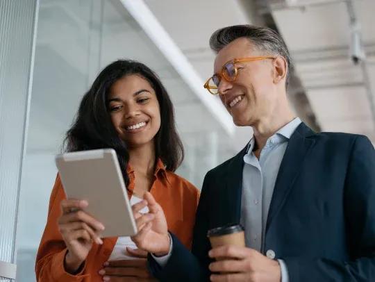 Two professional people look at an ipad