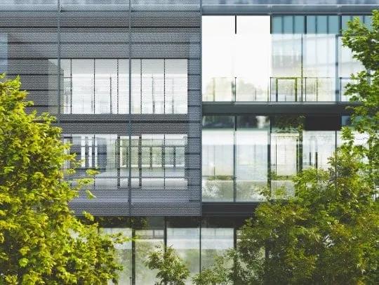 Des arbres verts devant un bâtiment moderne