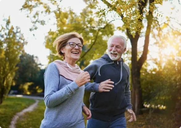 couple plus âgé, jogging à travers le parc