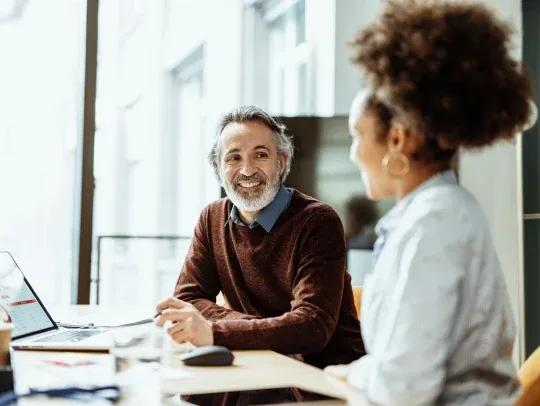 Middle aged man and women smiling in the office